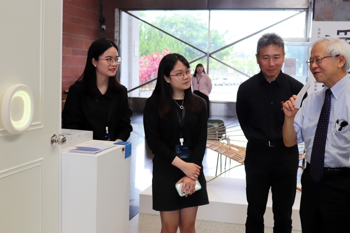 湯明哲校長(右一)與陳培茹(左一)、謝予慈(左二)同學討論「Boundoor」作品。右二為陳文誌系主任。